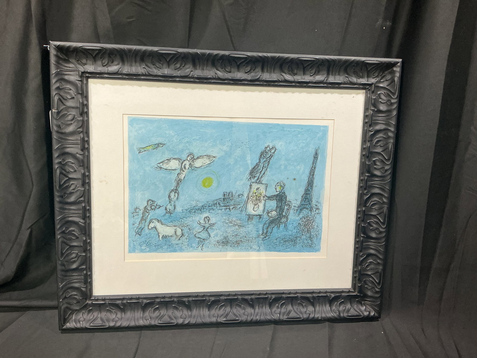 Modernist Figural Landscape Framed Print: Framed modernist style print depicting whimsical figures, animals, and an artist at easel in a dreamlike landscape. Blue-toned composition with expressive line work. Estimated shipping $40-$75.