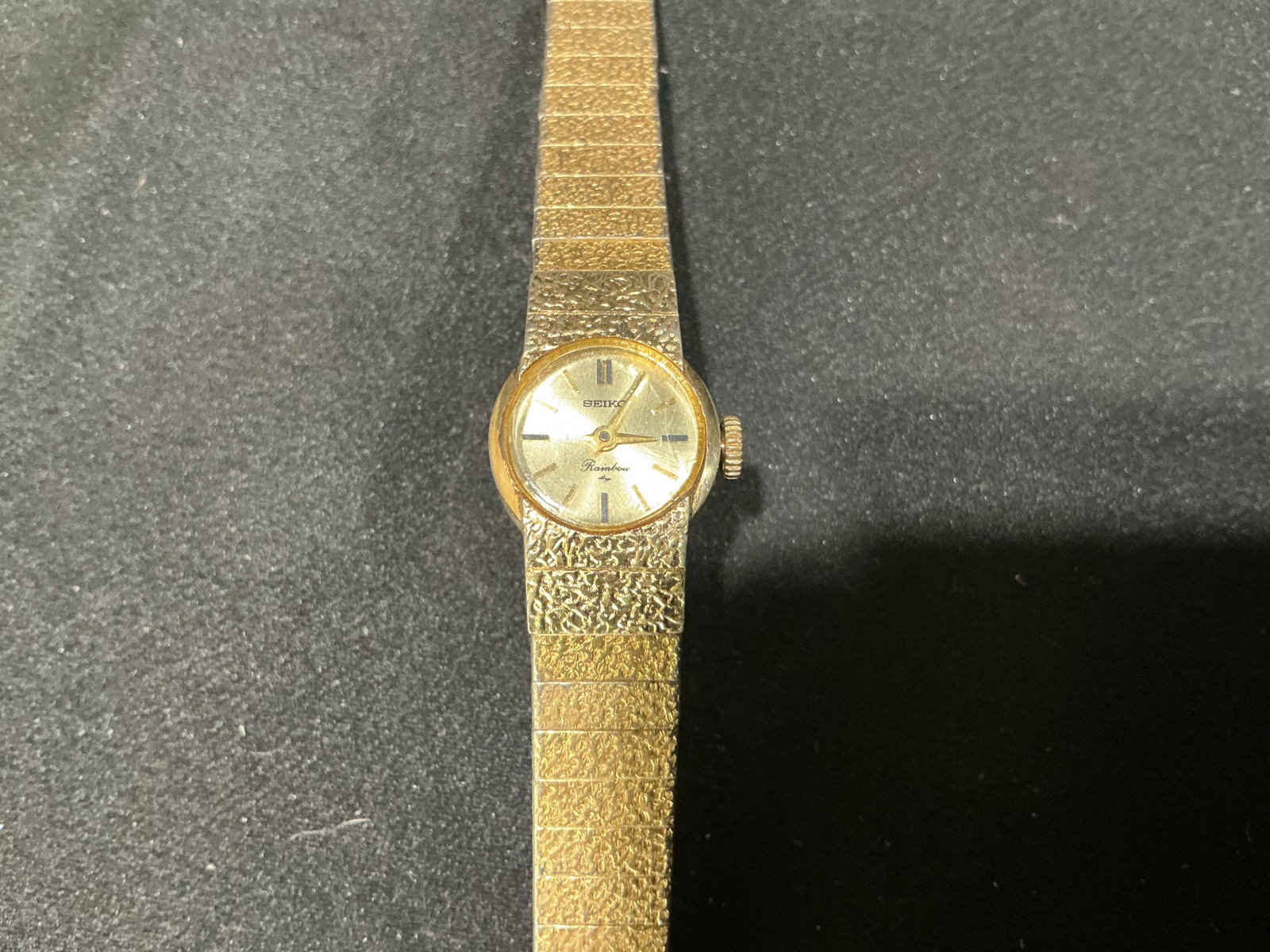 Vintage Wristwatch: Vintage wristwatch with gold-tone case, Swiss-made movement, and black leather strap. A classic mechanical dress watch offering vintage styling for collectors and everyday display. Estimated shipping