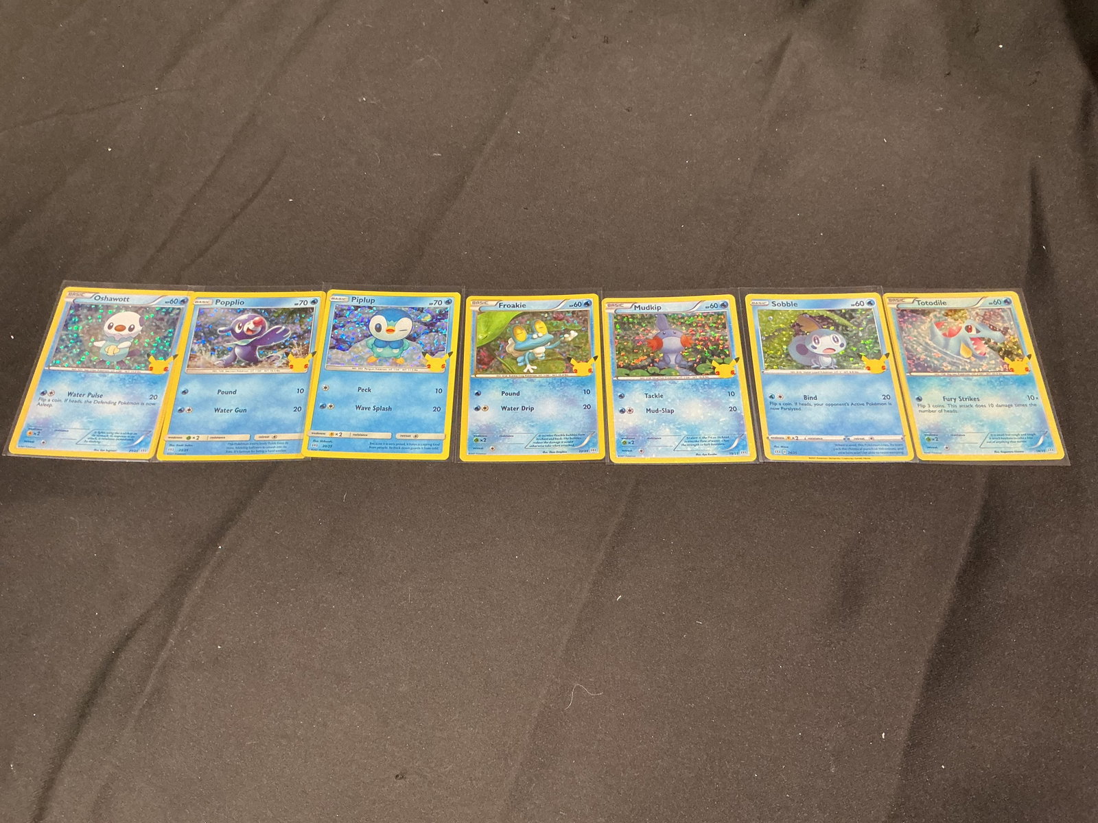 Pokemon McDonald's Water Holo Card Set: Featuring seven holographic Pokemon McDonald's 25th Anniversary promo cards, this themed water starter collection includes Sobble, Froakie, Totodile, Piplup, Mudkip, Popplio, and Oshawott. A colorful