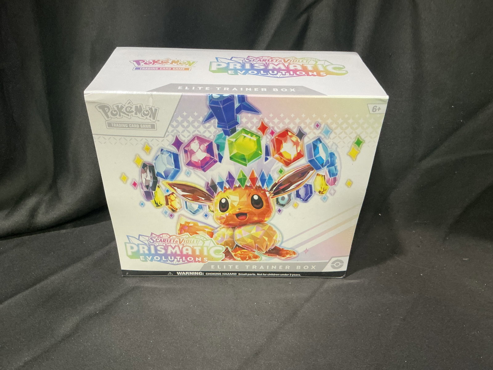 Prismatic Evolutions Eevee ETB: Eevee and the Eeveelutions return in this sealed Pokemon Scarlet & Violet Prismatic Evolutions Elite Trainer Box. Featuring booster packs, an exclusive promo card, themed sleeves, dice, markers, and t
