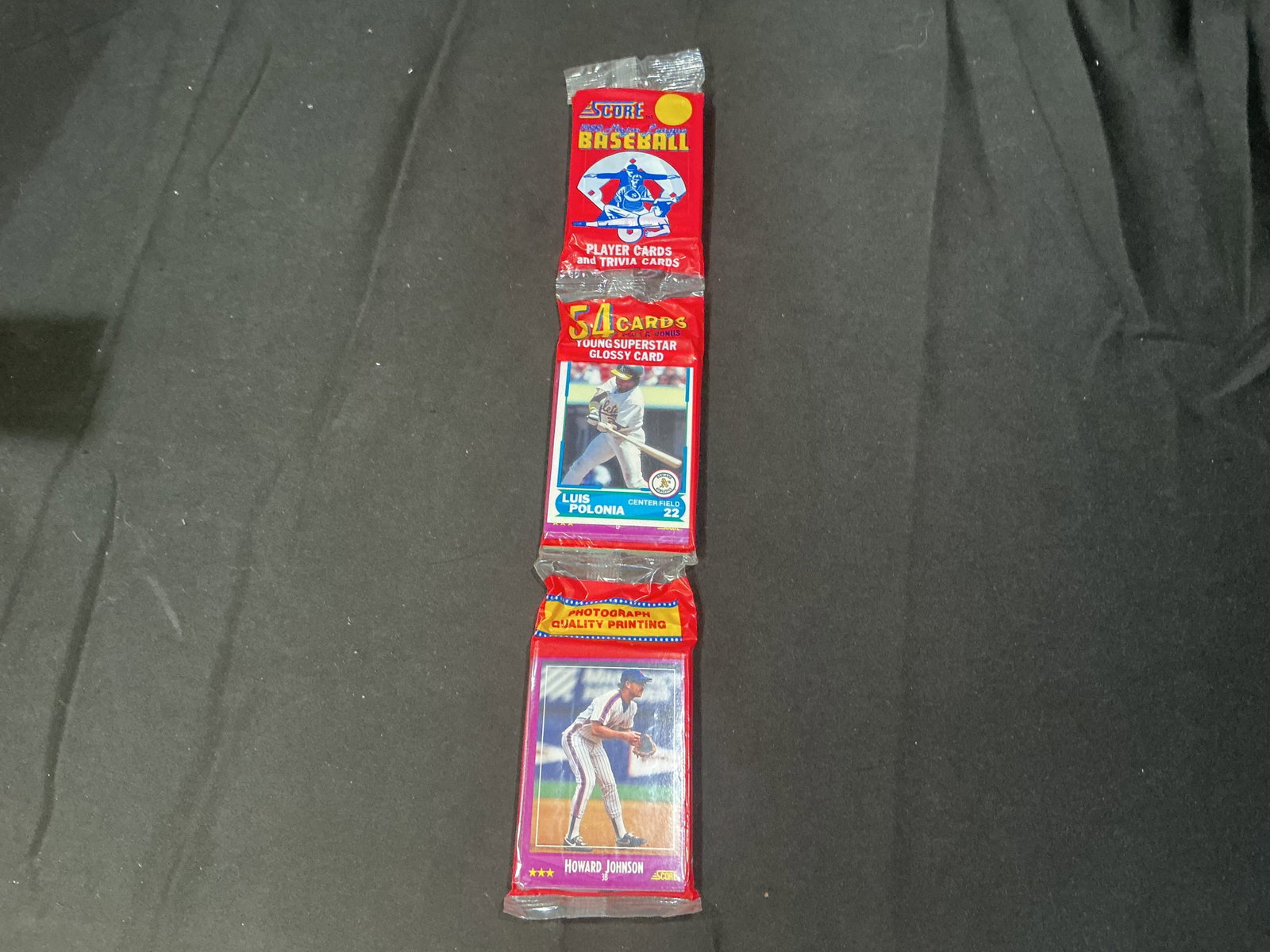 1988 Score Baseball Rack Pack: Factory sealed 1988 Score Baseball rack pack containing 54 player and trivia cards plus one Young Superstar glossy card. Example players visible include Luis Polonia and Howard Johnson. An affordable