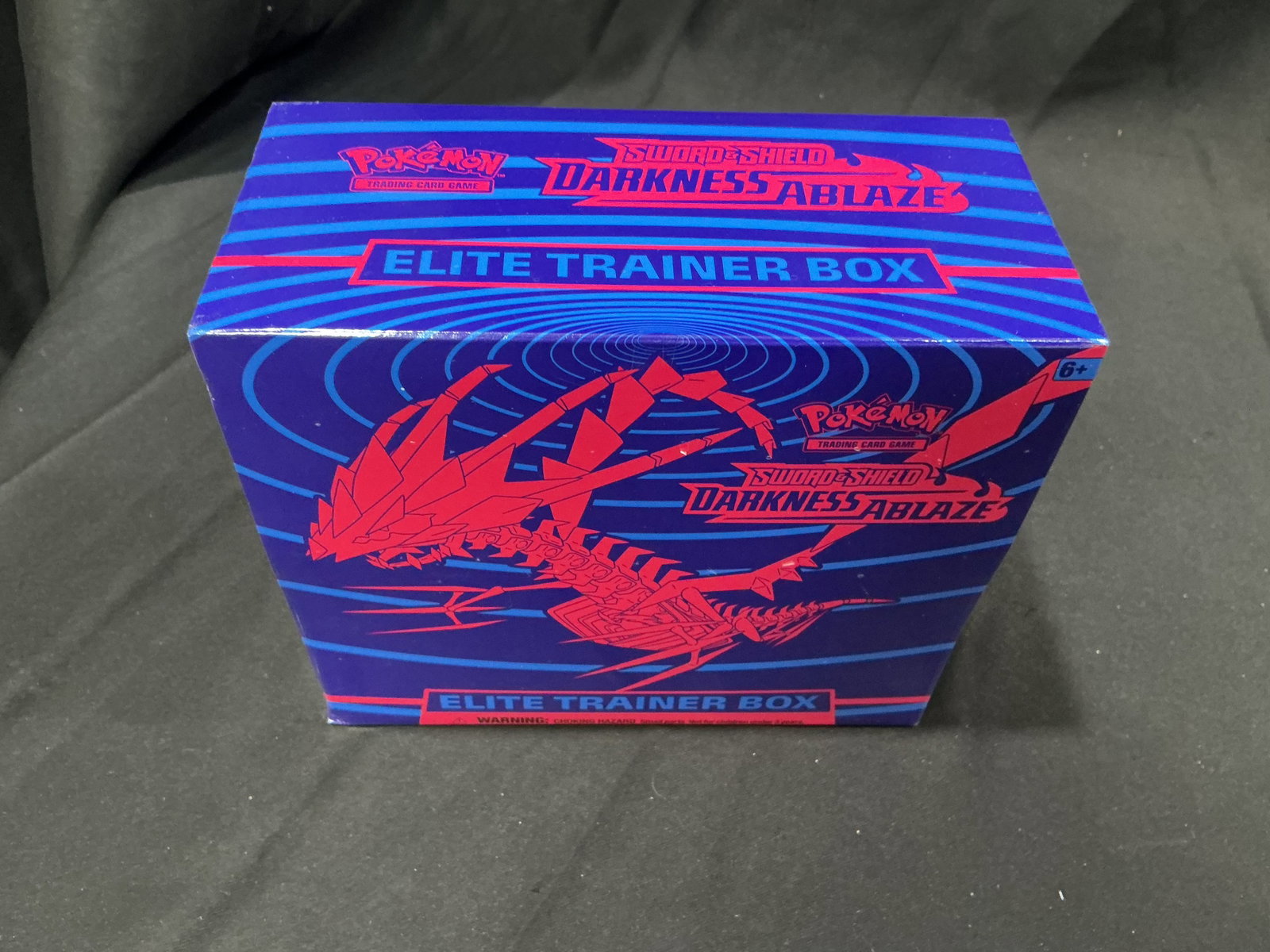 Pokemon Darkness Ablaze ETB: Returns after prior appearance, this factory sealed Pokemon Sword & Shield Darkness Ablaze Elite Trainer Box showcases Eternatus artwork and includes booster packs, card sleeves, dice, energy cards, a