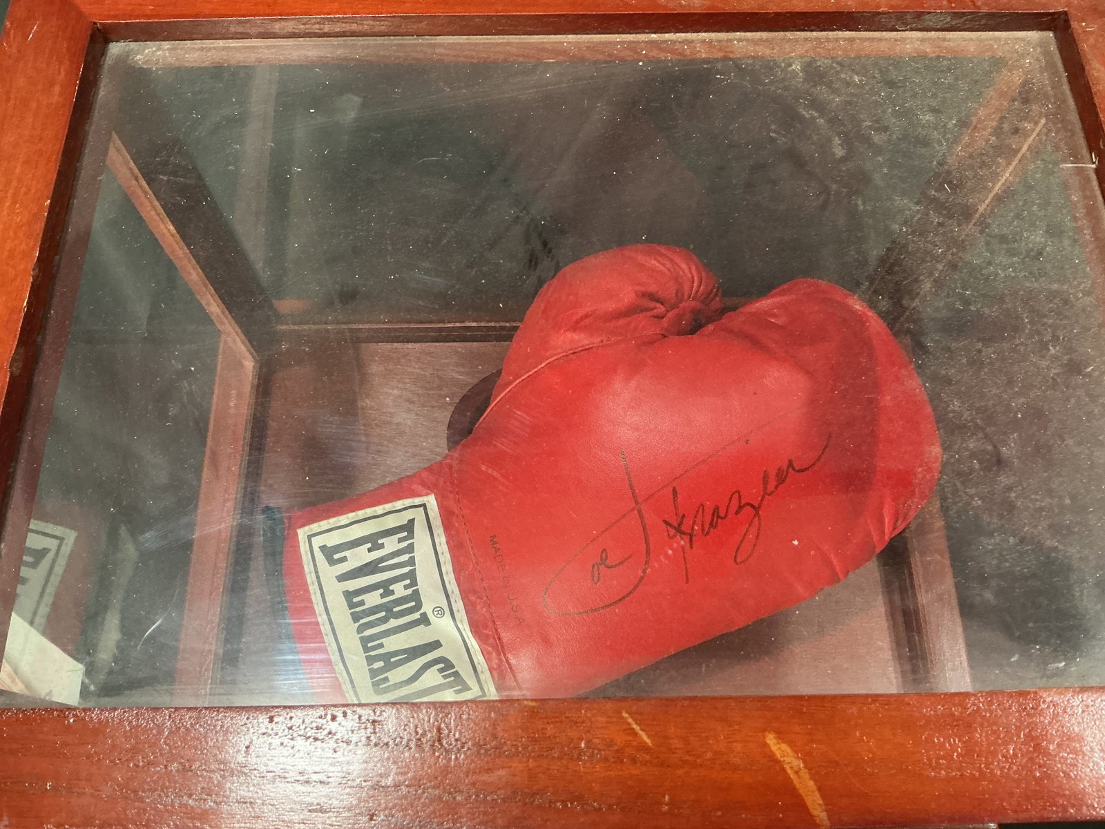 Joe Frazier Signed Everlast Glove: Returning after appearing in our previous auction, this red Everlast professional boxing glove is signed in black marker by Hall of Fame heavyweight champion Joe Frazier and displayed in a wooden and