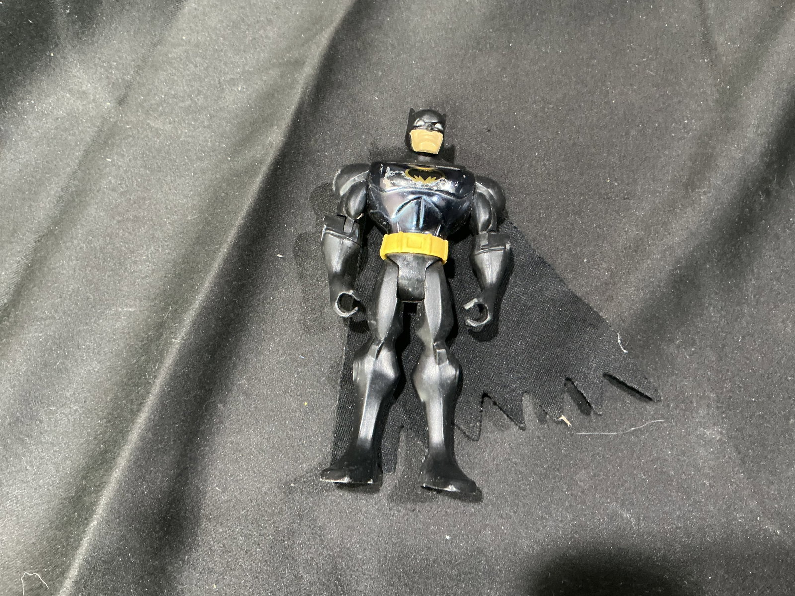 DC Batman Cloth Cape Figure: Back in the catalog after some time away, this late-1990s DC Comics Batman action figure by Mattel features a black suit, yellow utility belt, removable black cloth cape, and visible articulation.