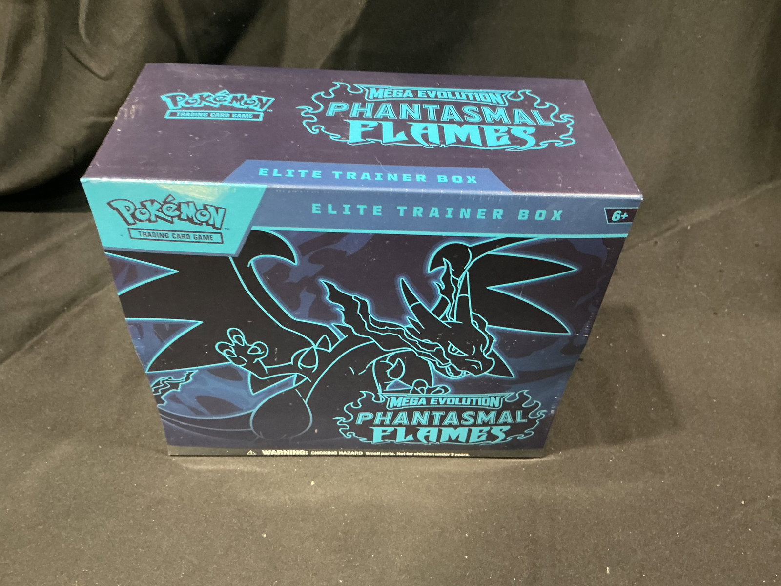 Phantasmal Flames ETB Sealed: Our one and only Phantasmal Flames Elite Trainer Box currently on offer from our inventory, this factory sealed Pokemon Mega Evolution release features Mega Charizard artwork with booster packs,