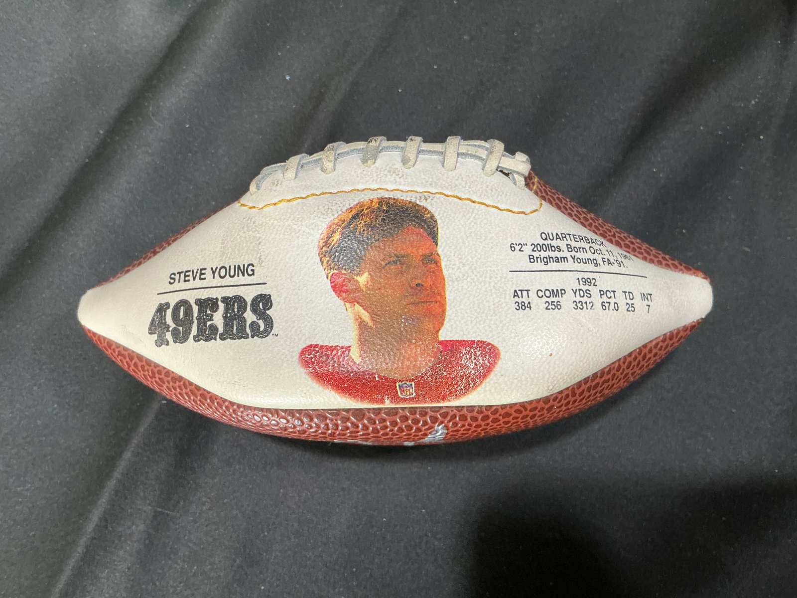 Steve Young Signed 49ers Mini Football: Appearing again, this San Francisco 49ers mini football features a Steve Young facsimile player portrait and career-stat design with a silver-tone signature across the football panel. A compact