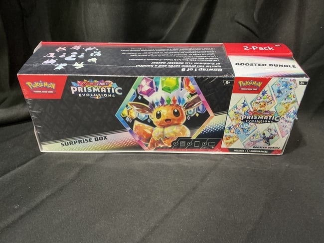 Prismatic Surprise Box & Bundle: Our one and only Prismatic Evolutions Surprise Box and Booster Bundle pairing in this auction brings together two factory sealed products from the popular release. The combination provides promo conte