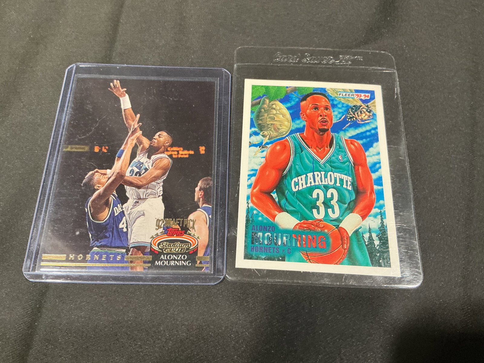 Alonzo Mourning Rookie Card Pair: Making another appearance, this Alonzo Mourning rookie card pair features a 1992 Topps Stadium Club Rookie Card #297 and a 1993-94 Fleer #234 card of the Hall of Fame center. The two-card grouping