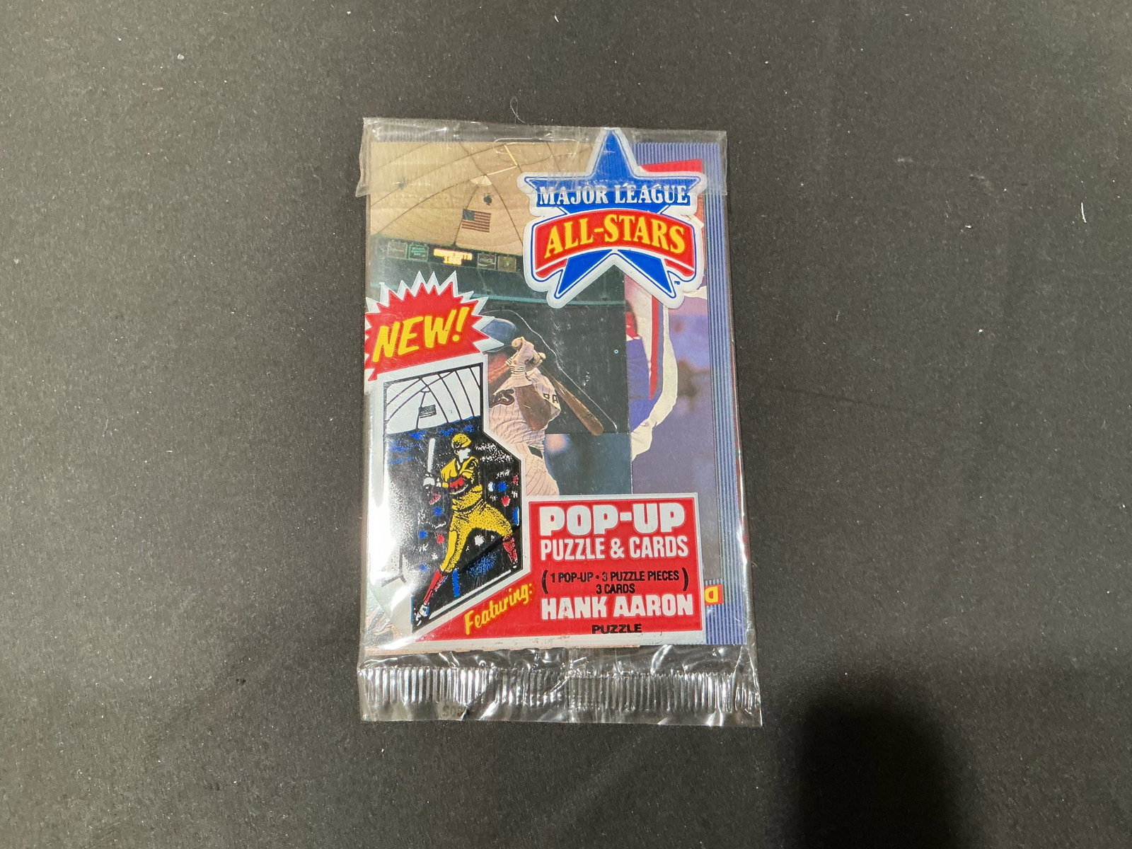 Major League All-Stars Hank Aaron Pop-Up Card Pack: A vintage Major League All-Stars Pop-Up Puzzle & Cards pack featuring a Hank Aaron puzzle and a collectible baseball pop-up. The original package contains one pop-up, three puzzle pieces, and three