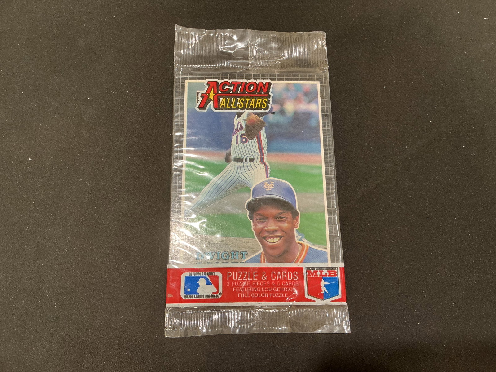 Dwight Gooden Action All-Stars Sealed Pack: Unopened Action All-Stars baseball Puzzle & Cards pack featuring New York Mets pitcher Dwight Gooden on the wrapper. Package states it contains three puzzle pieces and five cards featuring a Lou