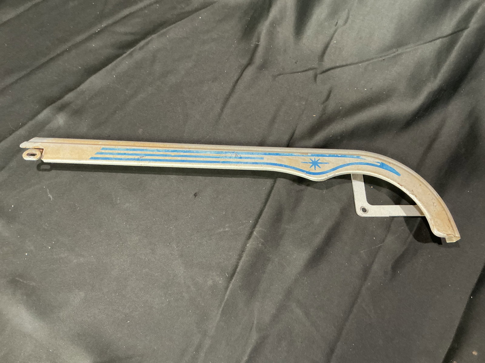 Schwinn Vintage Blue Graphic Chain Guard: Returning as a useful vintage bicycle restoration piece, this Schwinn chain guard features its original silver finish with blue striping and starburst graphic. Suitable for restoration of a period