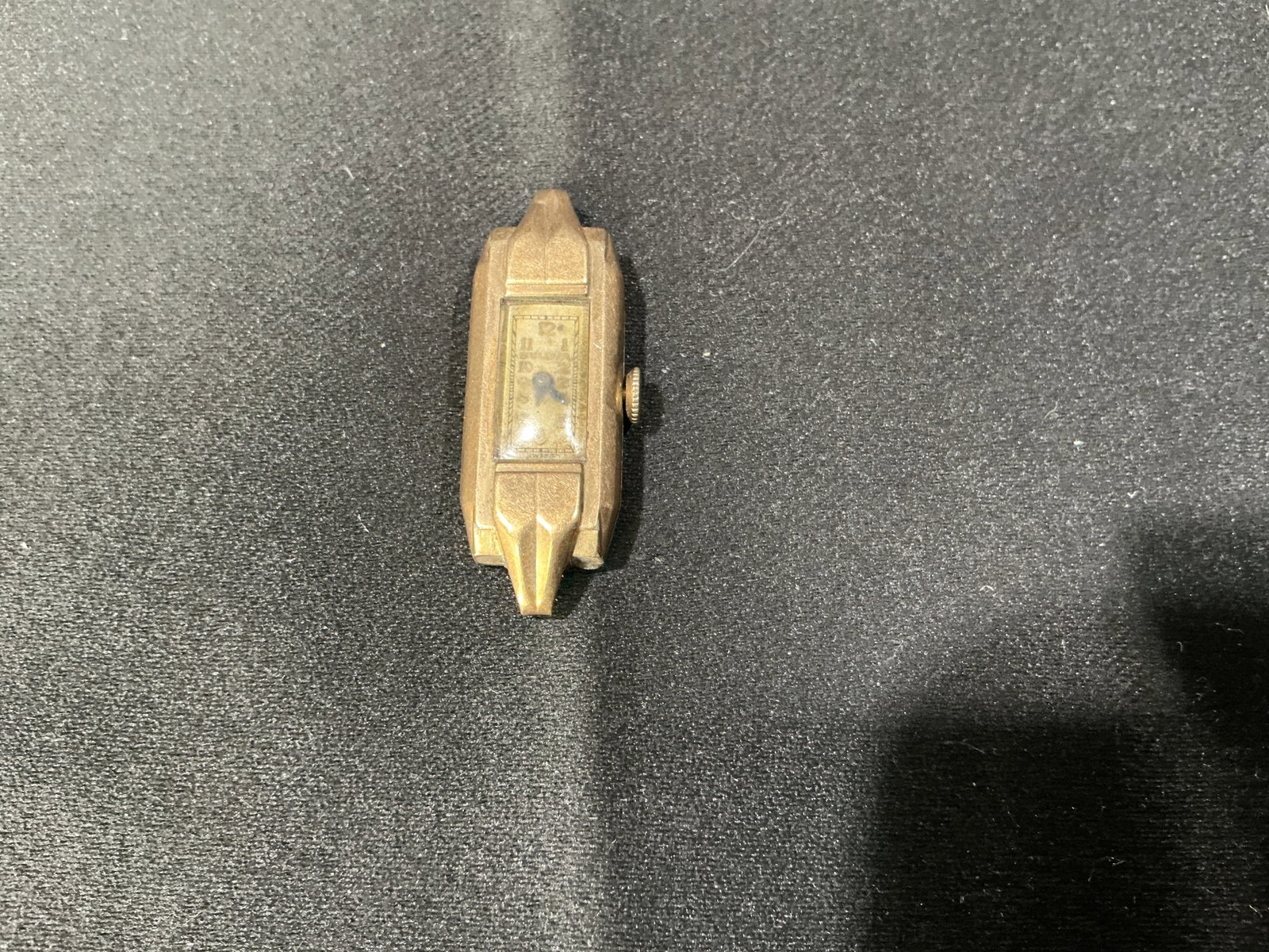 Vintage Art Deco Miniature Clock Desk Watch: Vintage Art Deco style miniature clock with geometric metal case and small dial. Compact form with decorative design, suitable as a desk, wrist or novelty timepiece. Likely mid-20th century.