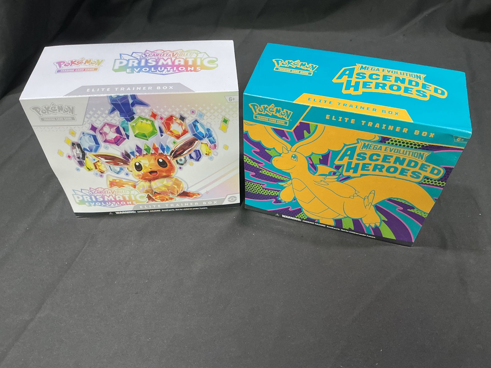 Prismatic Evolutions & Ascended Heroes ETBs: Back together for another opportunity, this factory sealed pairing features one Prismatic Evolutions Elite Trainer Box and one Mega Evolution Ascended Heroes Elite Trainer Box. Combining the