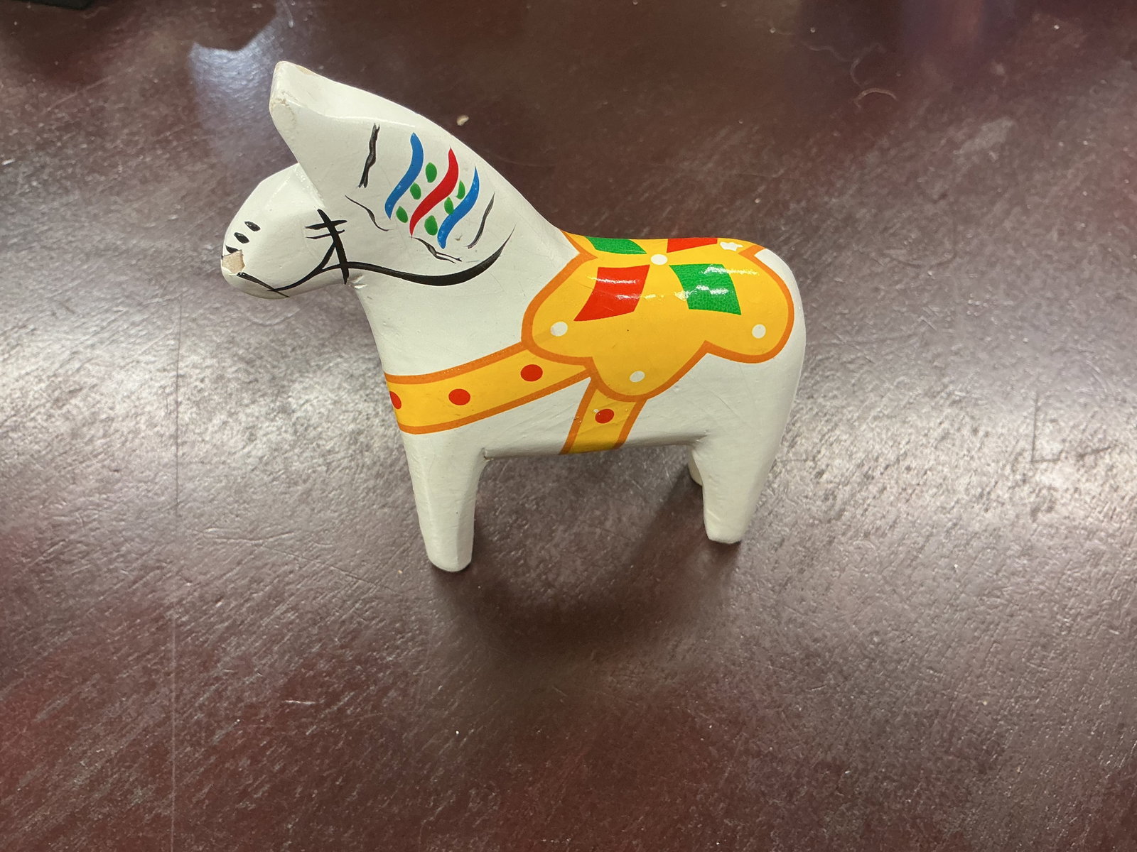 Swedish Dala Horse White Hand Painted Folk Art: Traditional Swedish Dala horse, or Dalahast, carved in wood with a white painted finish and colorful yellow, red, green, blue, and black folk-art decoration. The compact Scandinavian figure features