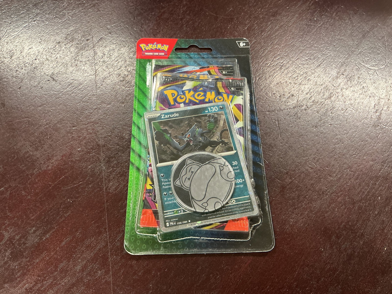 Pokemon Zarude Two Booster Pack Blister Sealed: Factory sealed Pokemon TCG blister featuring a foil Zarude promo card, metallic Pokemon coin, and two booster packs. The compact sealed format combines a character promo with two packs for collectors 