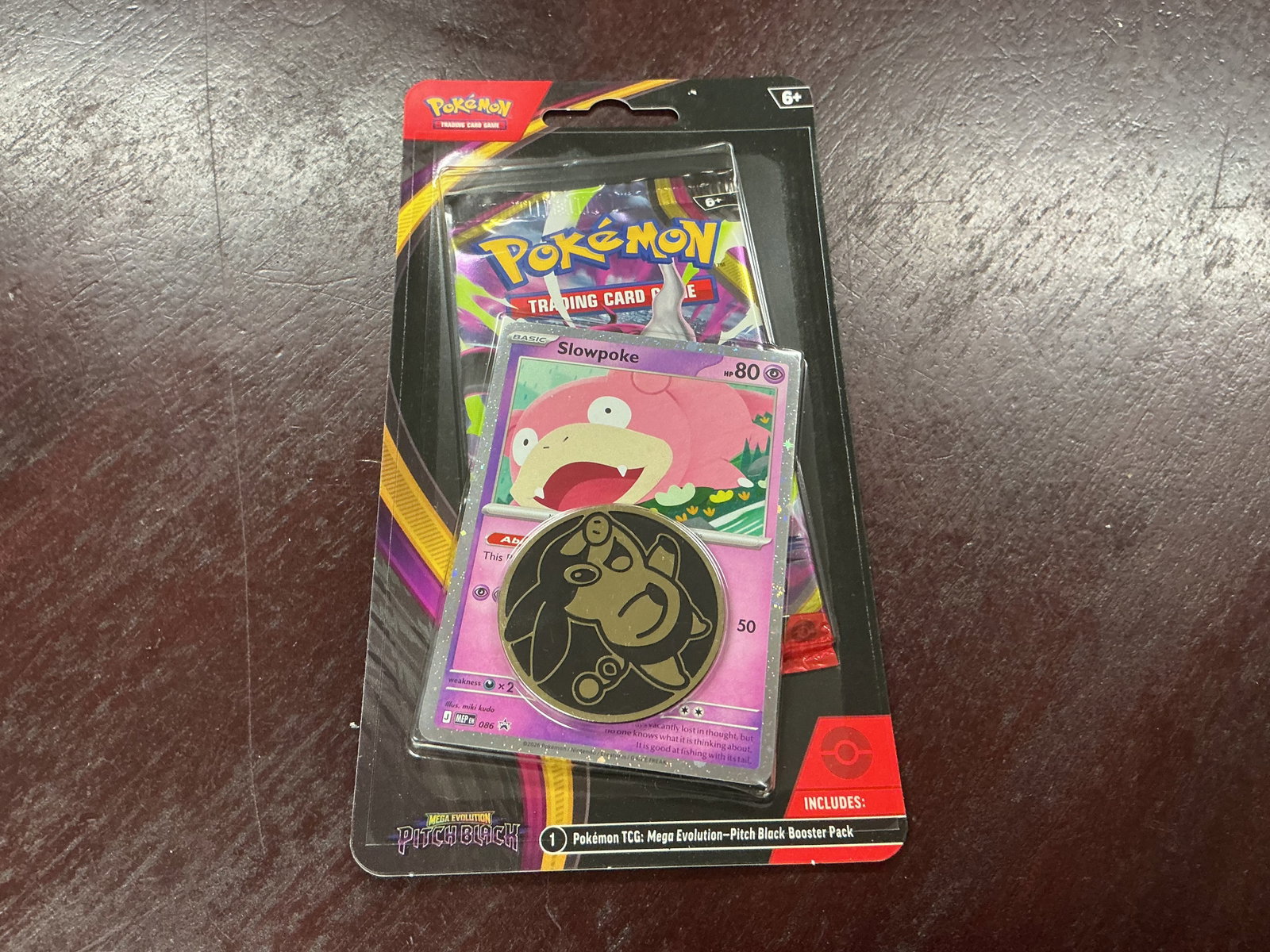 Pokemon Pitch Black Slowpoke Promo Blister Sealed: Factory sealed Pokemon TCG Mega Evolution Pitch Black blister featuring a Slowpoke promo card, Pokemon coin, and one Pitch Black booster pack. The prominently displayed Slowpoke card and character coi