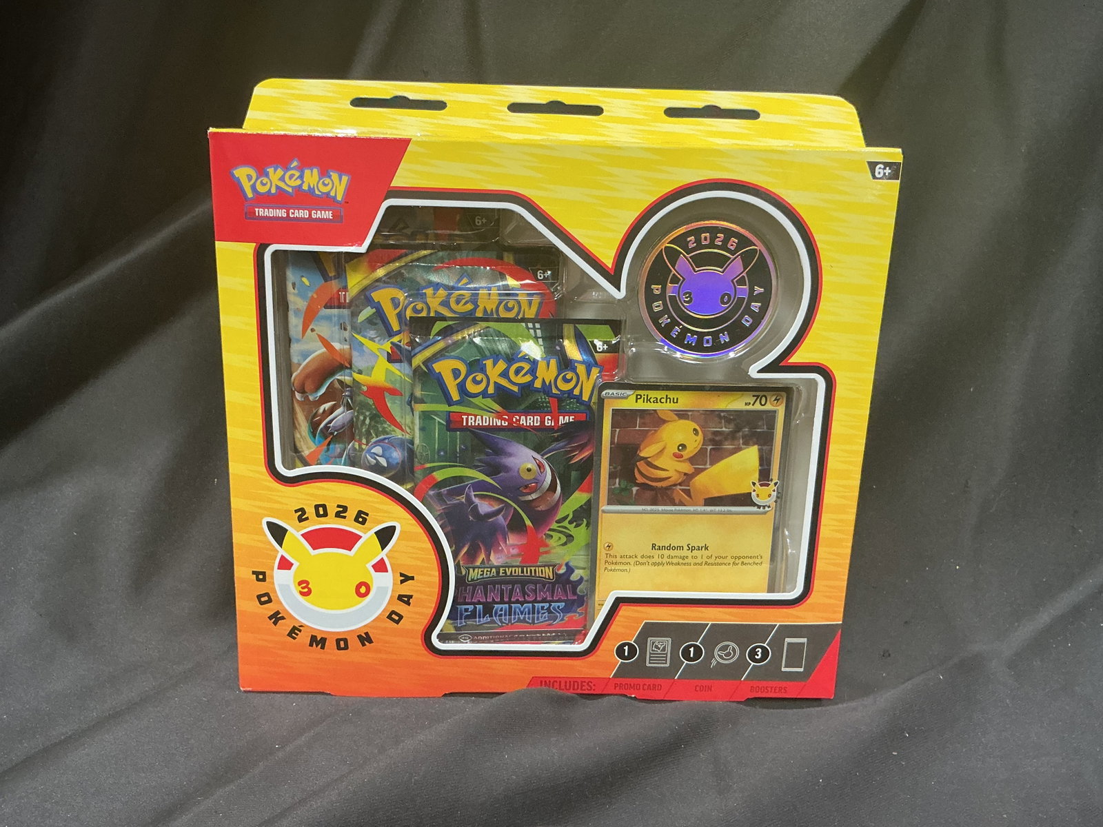 Pokemon Day 2026 Pikachu 30th Anniversary Collection: Appearing again for Pokemon's 30th anniversary is a factory sealed Pokemon Day 2026 Collection featuring a specially stamped foil Pikachu promo card. The box also contains a metallic anniversary coin