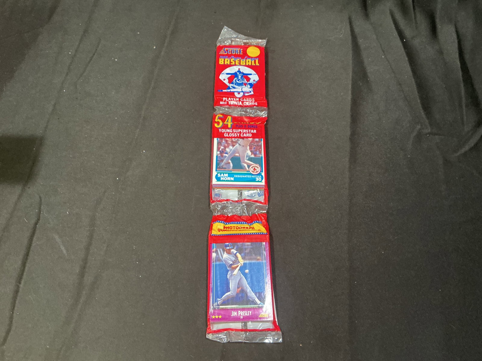 1988 Score Baseball Sealed Rack Pack Sam Horn Jim Presley: Making its first appearance in the auction, this factory sealed 1988 Score Major League Baseball rack pack contains 54 player and trivia cards plus a bonus Young Superstar glossy card. Sam Horn of the