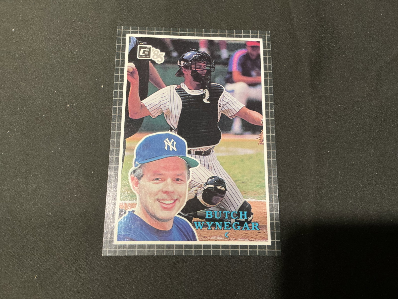 1985 Donruss Butch Wynegar Yankees #45 Oversized Card: Making its first appearance, this oversized 1985 Donruss baseball card features New York Yankees catcher Butch Wynegar, pictured in full catching gear with a portrait inset. The reverse identifies him