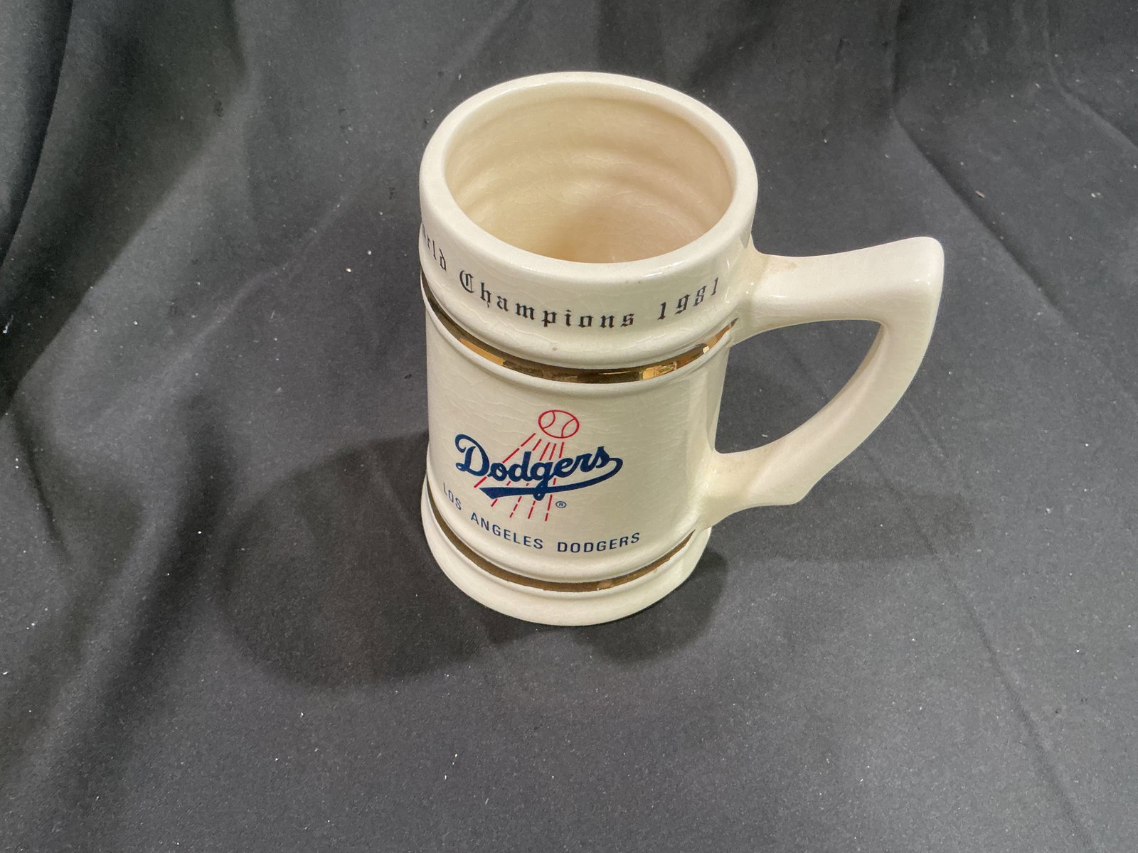 1981 Los Angeles Dodgers World Champions Ceramic Stein: Celebrating the Los Angeles Dodgers' 1981 World Championship season, this substantial ceramic stein features the classic Dodgers script logo, gold-tone accent bands, and World Champions 1981 lettering
