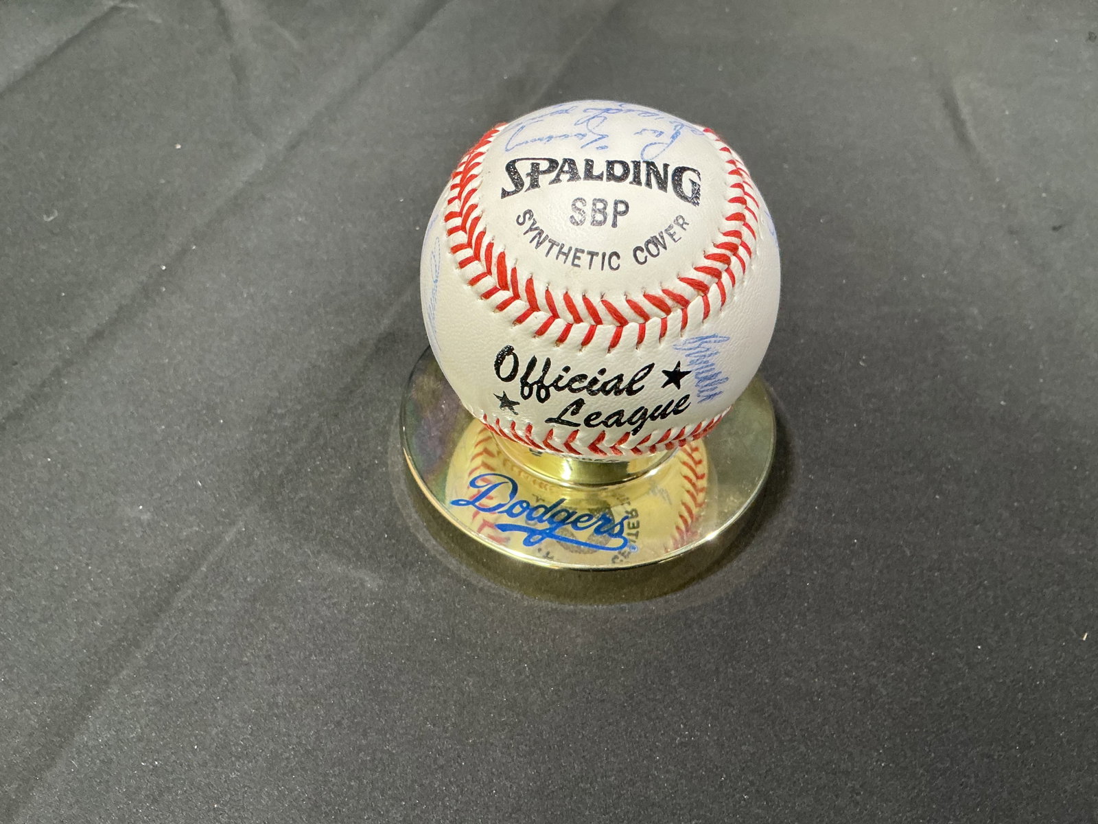 1983 Los Angeles Dodgers Multi-Signed Baseball with Provenance: A multi-signed Spalding SBP Official League baseball bearing numerous blue-ink signatures and accompanied by a Los Angeles Dodgers display base and clear dome. A handwritten note with the group is