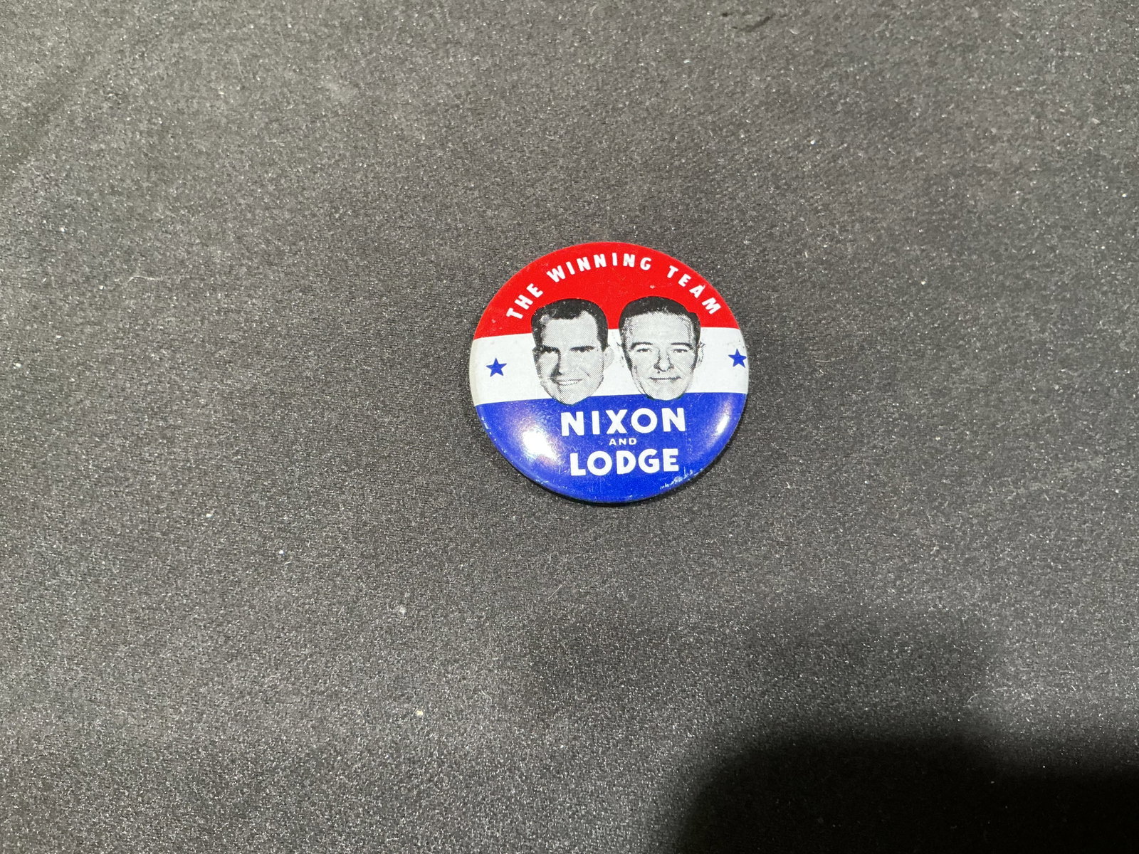 Nixon & Lodge The Winning Team Reproduction Pinback: A bold red, white and blue political pinback features portraits of Richard Nixon and Henry Cabot Lodge Jr. beneath the slogan "The Winning Team" and the names "Nixon and Lodge." The design recalls