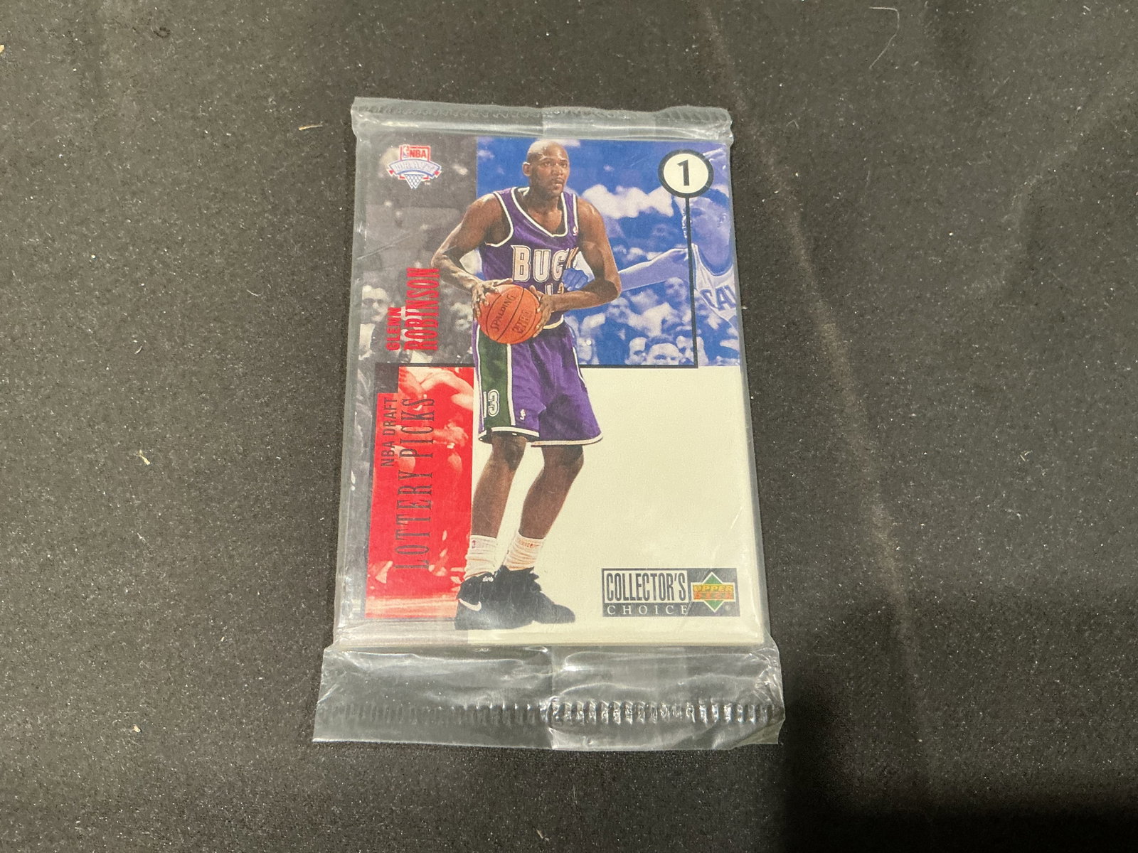 1994-95 Upper Deck Collector's Choice Factory Sealed Basketball Pack: A factory sealed 1994-95 Upper Deck Collector's Choice basketball pack shows Glenn Robinson, the first overall pick in the 1994 NBA Draft, on the top visible card and Los Angeles Lakers guard Eddie Jo