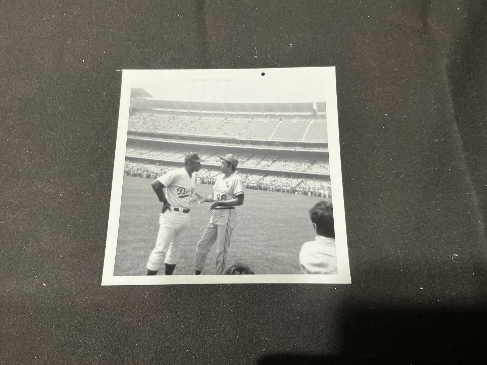 Vintage Los Angeles Dodgers Walter Alston Photo: A vintage black-and-white candid photograph captures longtime Los Angeles Dodgers manager Walter Alston on the field at Dodger Stadium in conversation with a uniformed player. The period stadium setti