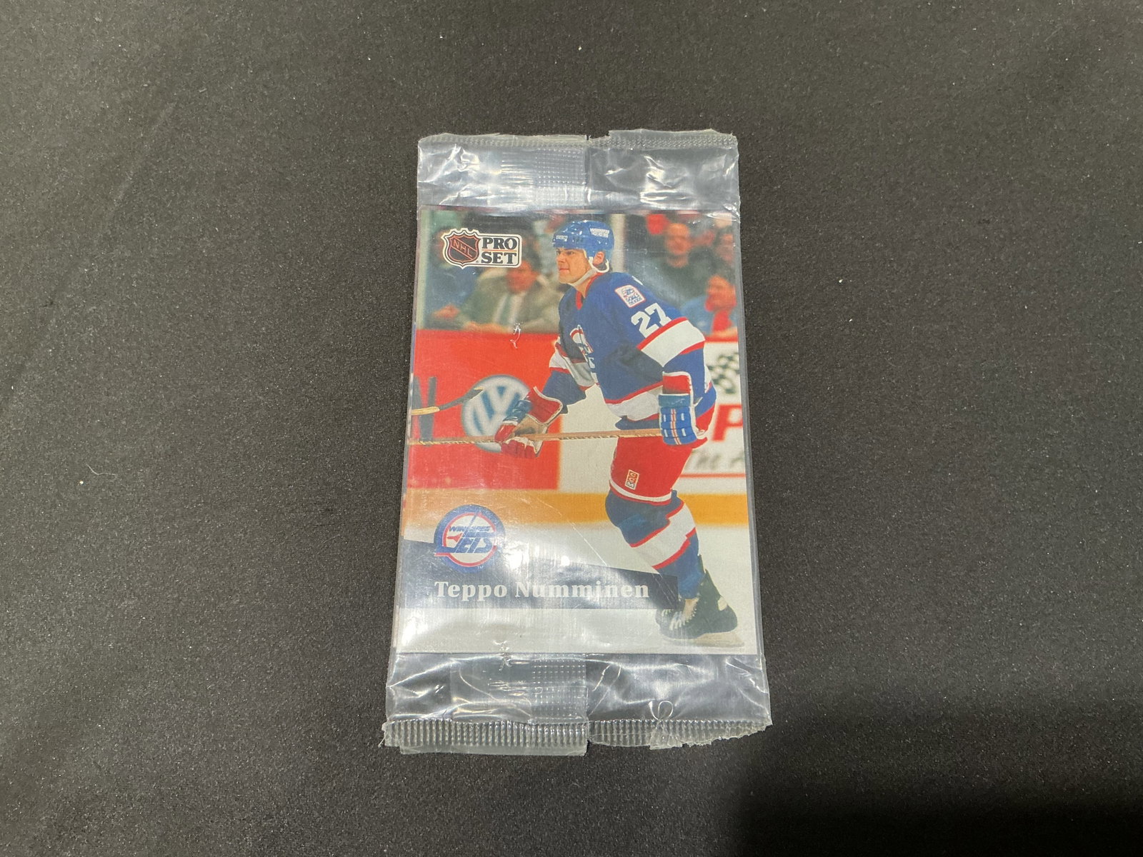 1991 Pro Set NHL Hockey Sealed Pack Teppo Numminen: Back in sealed pack form, this 1991 Pro Set NHL hockey card pack shows Winnipeg Jets defenseman Teppo Numminen on the front and Philadelphia Flyers center Mike Ricci #170 on the reverse. The original