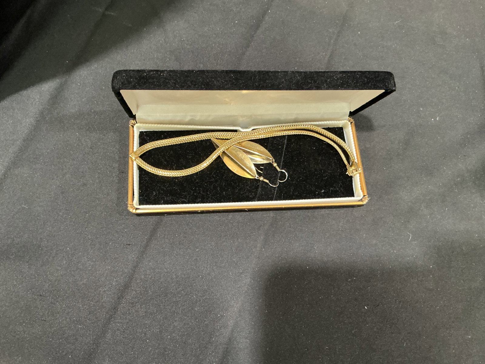 Vintage Gold-Tone Mesh Necklace & Pendant in Box: Presented in its fitted vintage jewelry box, this gold-tone necklace features a flexible woven mesh chain paired with a sculptural leaf- or petal-form pendant. The polished mid-century-inspired design