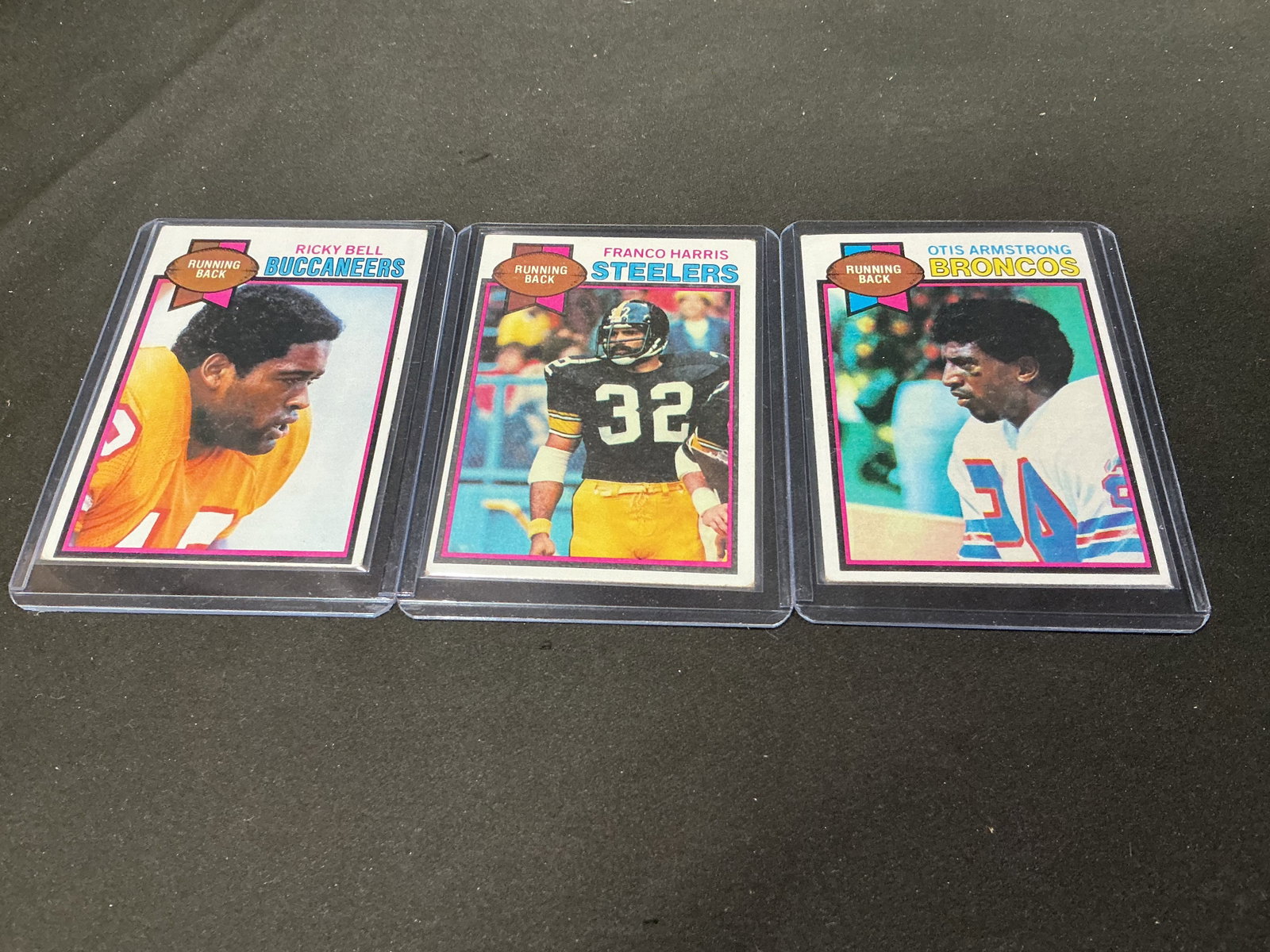 1979 Topps Franco Harris Ricky Bell Otis Armstrong Trio: Back in the auction as a three-card 1979 Topps football grouping, this lot brings together Pittsburgh Steelers Hall of Fame running back Franco Harris #300, Tampa Bay Buccaneers running back Ricky Bel