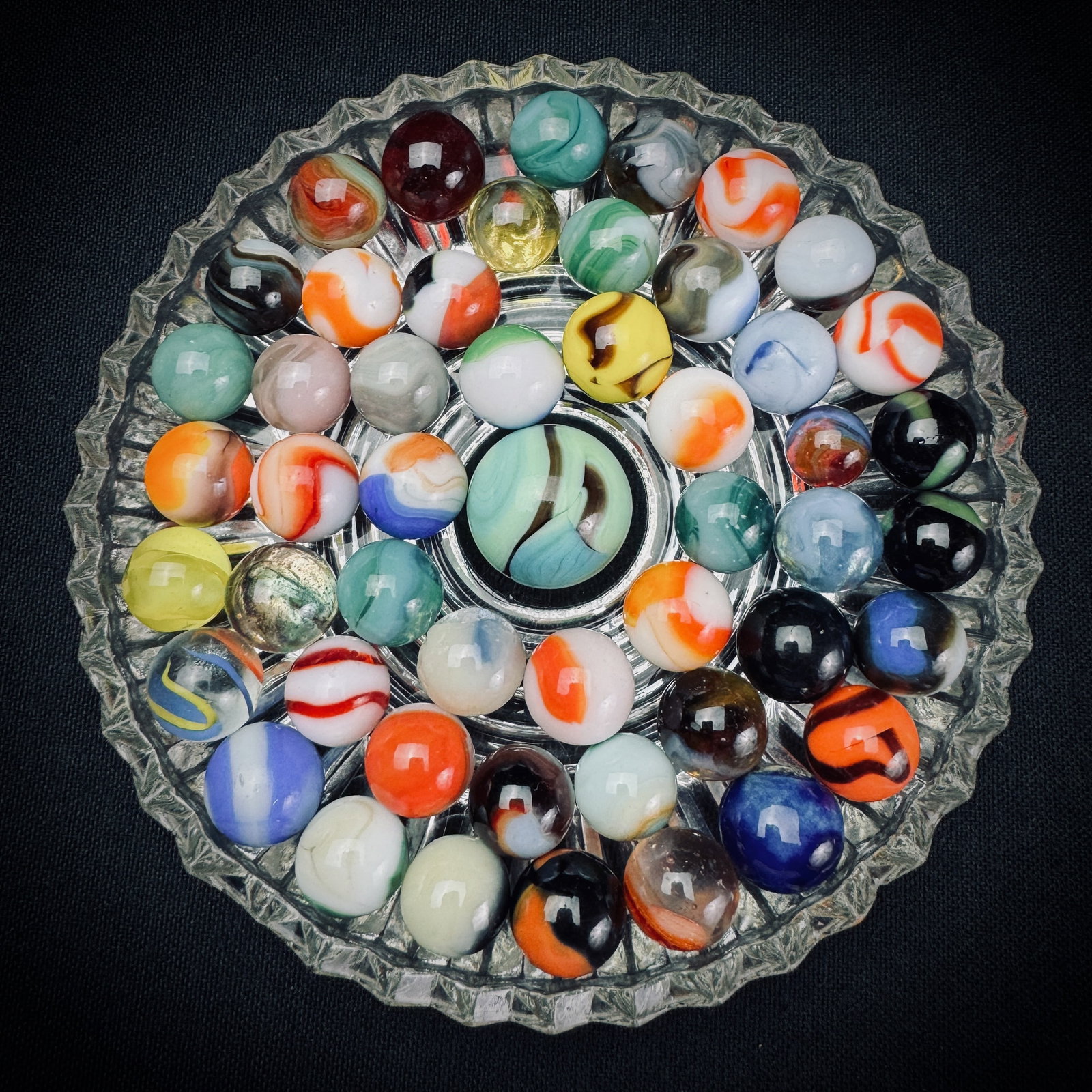 Lot of Vintage Glass Marbles with Shooter: This is a lot of assorted glass marbles in various colors and patterns. The lot includes multiple patch, swirl, and opaque type marbles, along with one larger shooter. Player marbles are approximately