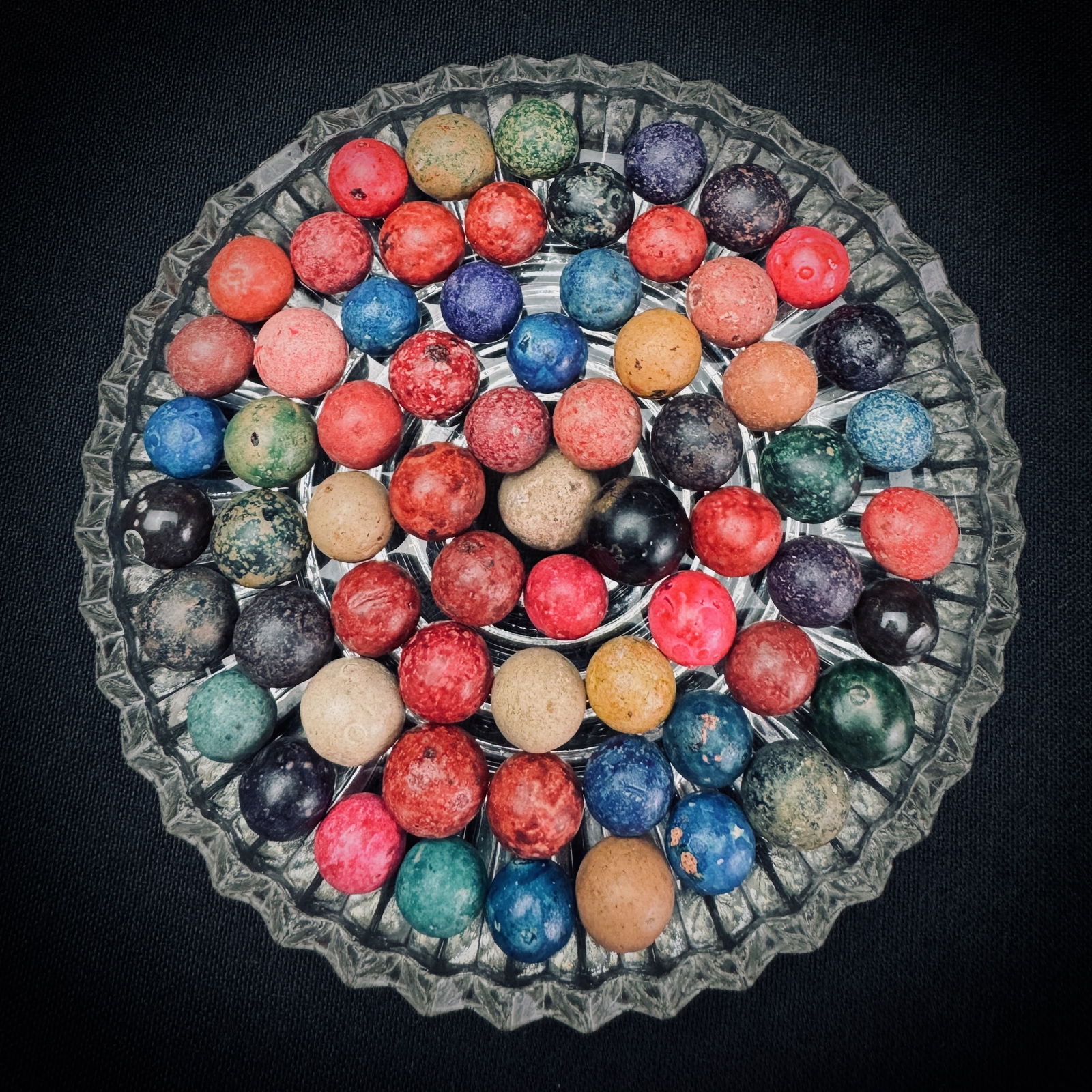 Lot of Vintage Multi-Color Clay Marbles: A collection of vintage clay marbles in various colors. This lot includes solids and mottled patterns in red, blue, green, black, and earth tones. The marbles have a characteristic unglazed, textured