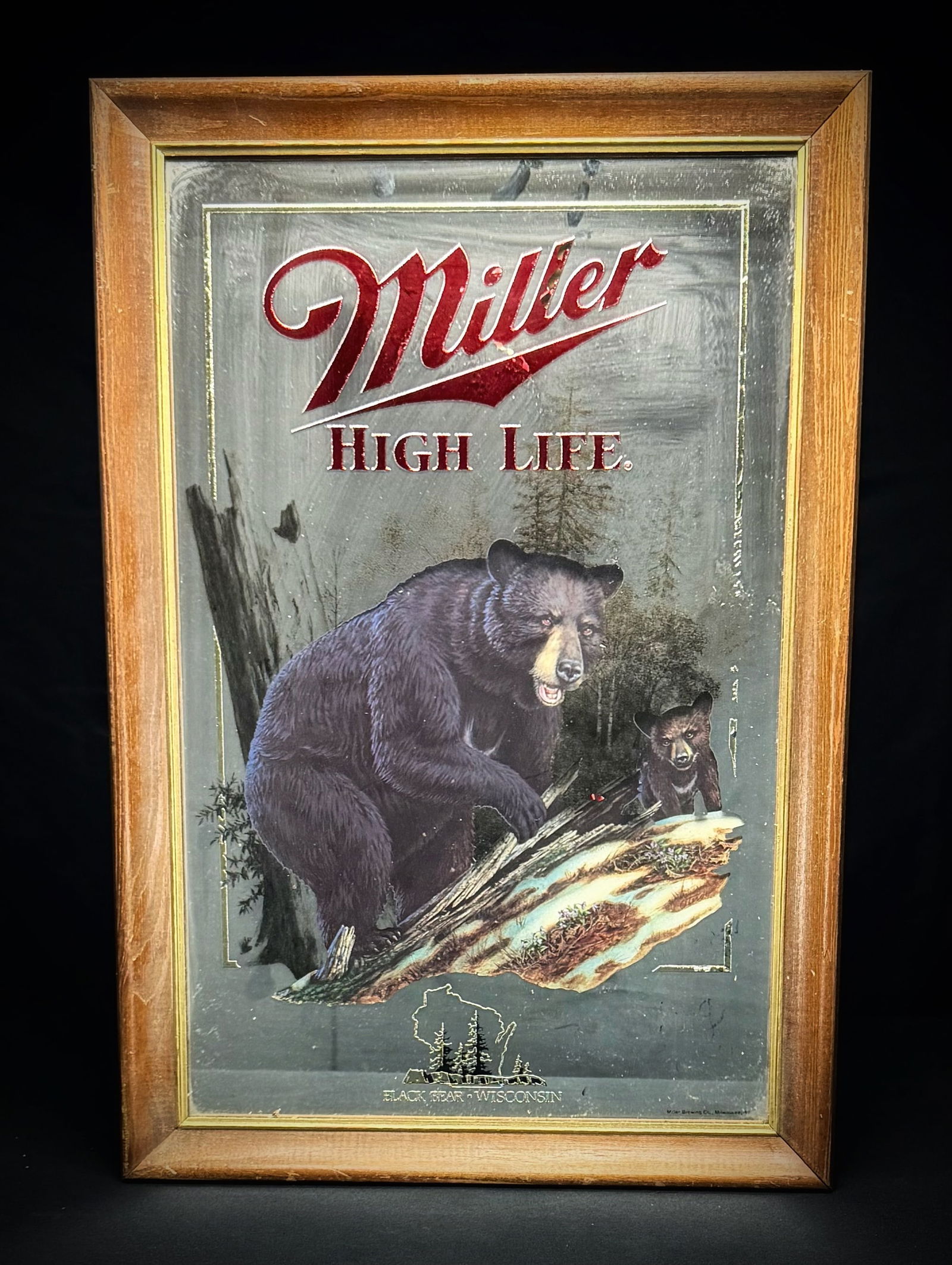 1981 Miller High Life Black Bear Mirror: This is a vintage Miller High Life promotional bar mirror from the Wildlife Series. It features artwork of a black bear and its cub in a woodland scene, representative of Wisconsin wildlife. The piece