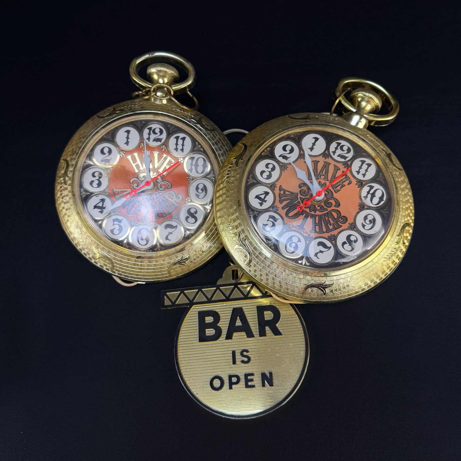 Vintage Spartus Bar Wall Clocks & Sign: This lot features a pair of vintage Spartus electric wall clocks designed in the shape of oversized pocket watches. Each clock has a gold-tone finish and a novelty face with pool ball style numerals t