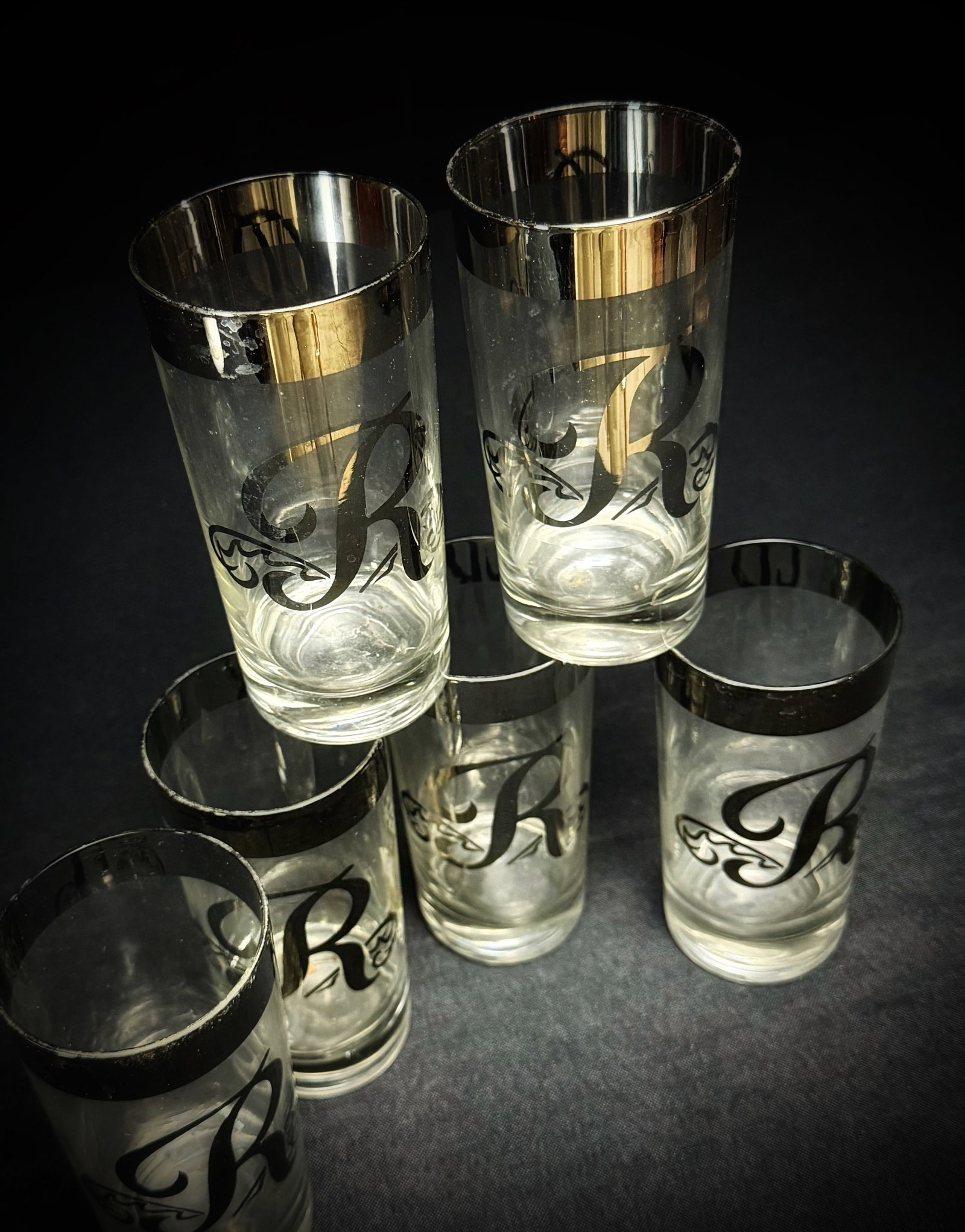 Vintage 'R' Monogram Silver Rim Tumblers (6): This is a set of six vintage glass tumblers. Each glass features a thick, silver-colored band around the rim and a large, stylized black 'R' monogram. The glasses are constructed with a heavy, weighte
