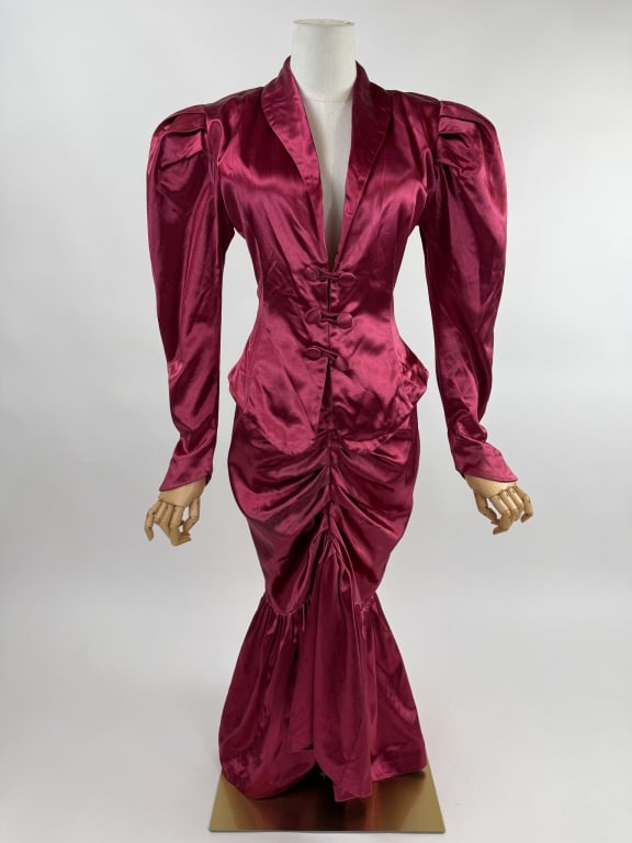 Vintage 1980s Norma Kamali Red Satin Skirt Suit: Vintage 1980s Norma Kamali Red Satin Skirt Suit. Large puffed sleeves with shoulder pads. Jacket closes at front with toggle buttons. Skirt has pleated details down front and zips at back to close. Ja