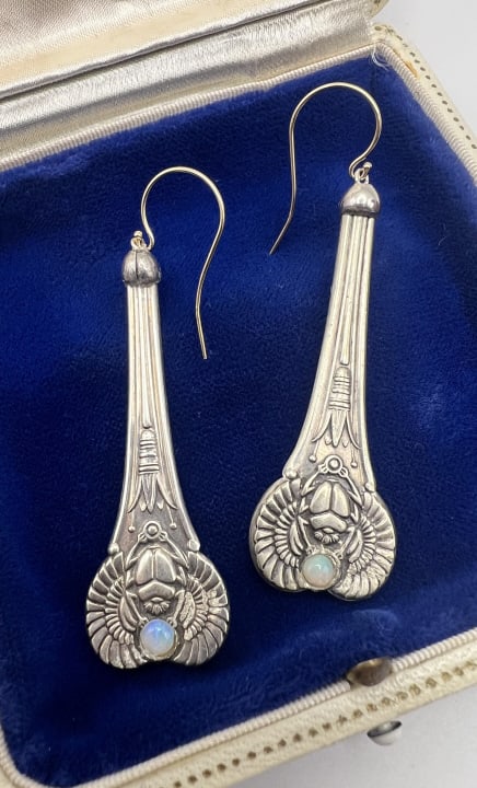 14kt Gold & Silver Moonstone Egyptian Earrings: Estate 14kt Yellow Gold, Silver & Moonstone Egyptian Earrings. Hallmarked 14kt gold ear wires, silver pendant drops each set with a cabochon moonstone in winged scarab design. Each measures 2.5 inches