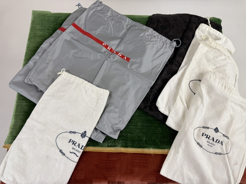 Collection of Prada & Gucci Designer Dust Bags: Collection of Prada & Gucci Designer Dust Bags. 7 total with 6 logo Prada and 1 Gucci monogrammed satin. Shoe and bag dust bags. Largest measures 15 inches by 13 inches.