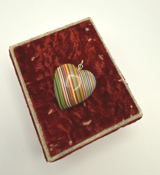 Vintage Fordite Motor Agate Heart Charm Pendant: Vintage Fordite Motor Agate Heart Charm Pendant. Made of layers of automotive paint and shaped into a heart. With metal bail at top. Measures approximately 1.5 inches including bail.