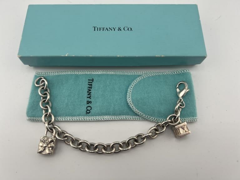 Vintage Tiffany & Co Sterling Charms on Bracelet: Vintage Tiffany & Co Sterling Charms on Bracelet. The bracelet is hallmarked 925 for sterling silver. The two charms are both hallmarked for sterling and signed Tiffany & Co. Comes with Tiffany & Co b