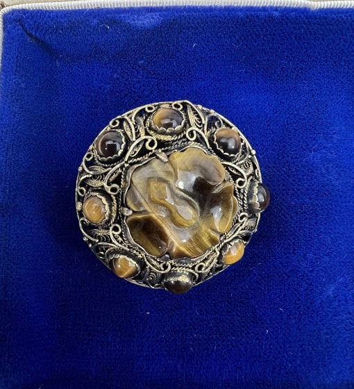 Estate Chinese Silver & Tiger's Eye Brooch Pin: Estate Chinese Silver & Tiger's Eye Brooch Pin. Filigree work construction with carved and cabochon tiger's eyes. Stamped SILVER on the back. Measures just over 1.25 inches in diameter. This lot is