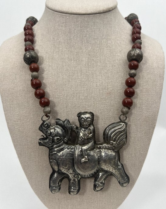 Antique Chinese Silver & Red Jasper Necklace: Antique Chinese Silver & Red Jasper Necklace. Antique Chinese repousse silver pendant with finely chased detail work of figure on back of mythological beast. Beaded necklace strand with round jasper