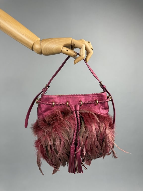 DKNY Donna Karan Pink Leather & Feather Bag: DKNY Donna Karan Pink Metallic Leather & Feather Shoulder Bag Purse. Braided rope belt with fringe around top opening. Closes with magnetic snap. Comes with dust bag. Adjustable shoulder strap. One in