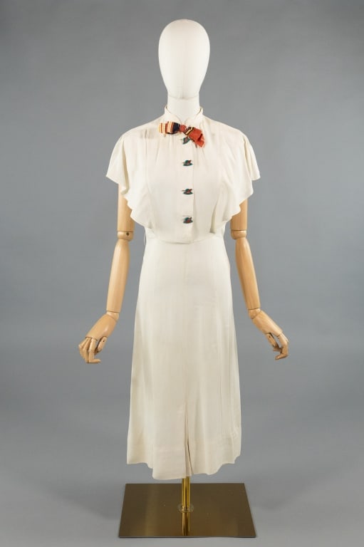 Vintage 1930s White Rayon Deco Day Dress: Vintage 1930s White Rayon Novelty Button Art Deco Day Dress. With flutter sleeves. Stripe bow detail at neck and novelty button closure down center front. Hooks and snaps at waist. Light wear