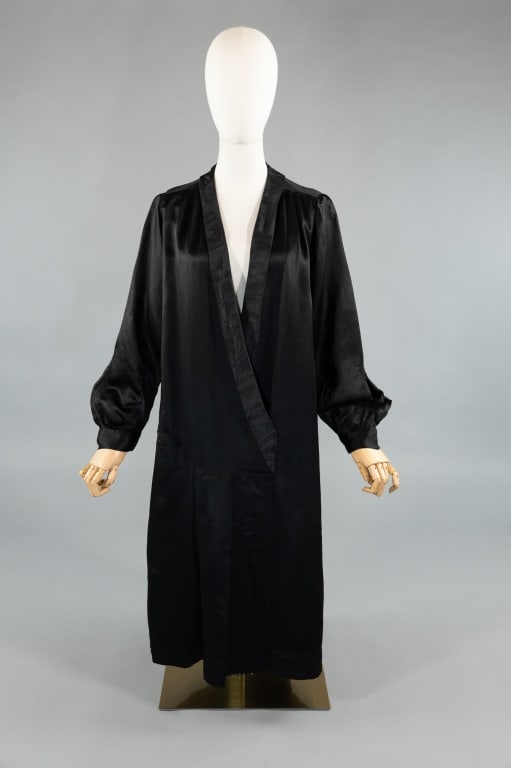 Antique 1920s Black Silk Satin Shift Coat Dress: Antique 1920s Black Silk Satin Shift Coat Dress. Shawl collar with long sleeves and snap closure at front. Single welt pocket at drop waist. Light wear throughout as shown, specifically at sleeves.
