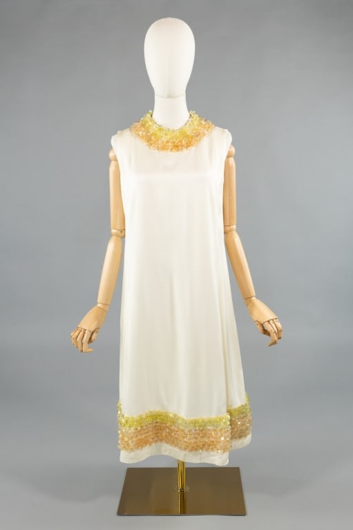 Vintage 1960s White Paliette Embellished Dress: Vintage 1960s White Silk Paliette Embellished A-Line Dress. With embellishments at neck and hem. A-line shape with zip closure at center back. Fully lined. Measures 40 inch bust, 36 inch waist, 40 inc