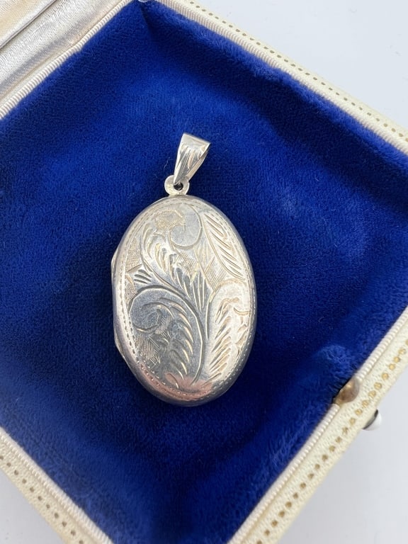 Vintage Chased Sterling Silver Oval Locket: Vintage Chased Sterling Silver Oval Locket Necklace Pendant. Hallmarked interior. Chased scrollwork design. Measures 1.75 inches in length.