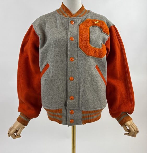 Vintage 1950s Champion Grey Wool Varsity Jacket: Vintage 1950s Champion Running Man Grey & Orange Wool Button Front Varsity Jacket. Buttons up front to close. Two front welt pockets. Ribbed collar, cuffs, and hem. C patch at breast. Light wear and h