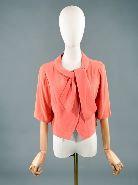 Vintage 1960s Pierre Cardin Crepe Mod Blouse Top: Vintage 1960s Pierre Cardin Crepe Mod Blouse Top having angular front snap closure with tie at neck and short sleeves, fully lined. Labeled Original Design by Pierre Cardin Paris. Measuring 40 inch bu